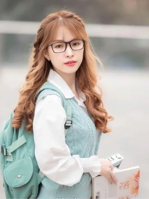 Woman with red hair and glasses carrying a backpack